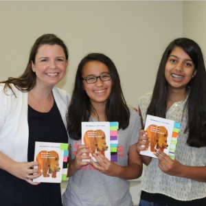 Girl Scouts Sara and Luisa and Tandem's Julie Barton with adapted books.
